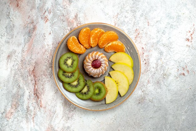 Top view different fruits composition fresh and sliced fruits on the white background ripe fruits mellow color health