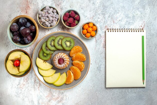 Top view different fruits composition fresh and sliced fruits on a white background vitamine mellow fruits health ripe