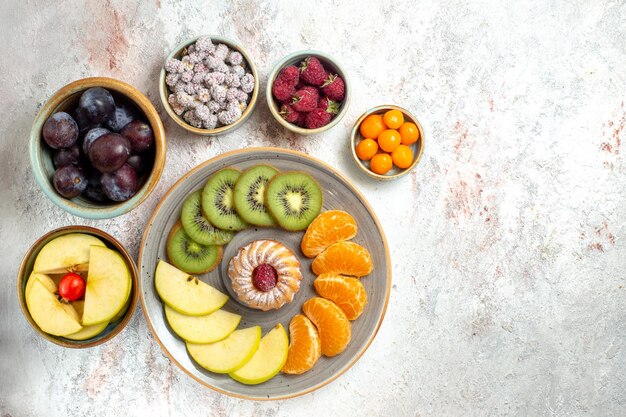 Top view different fruits composition fresh and sliced fruits on white background vitamine mellow fruits health ripe