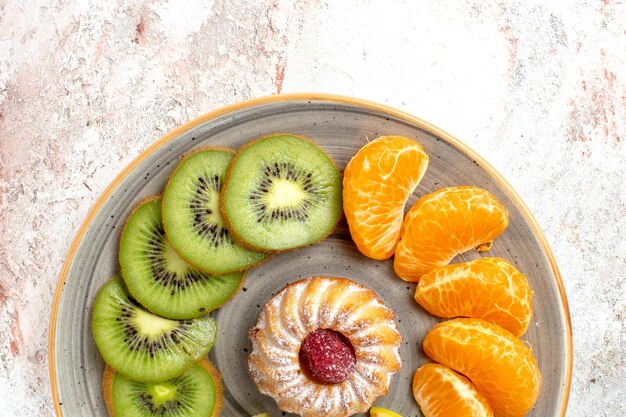 Top view different fruits composition fresh and sliced fruits with cake on light-white background mellow ripe fruits color health