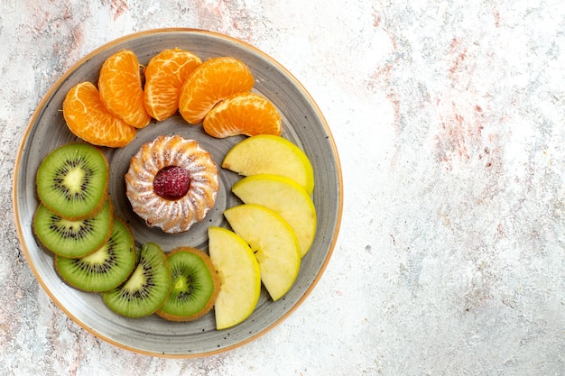 Вид сверху разные фруктовые композиции, свежие и нарезанные фрукты с тортом на белом фоне, спелые спелые фрукты, цвет здоровья