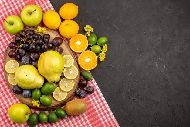 Вид сверху на разные фруктовые композиции, спелые и спелые фрукты на темном столе, спелые свежие спелые фрукты