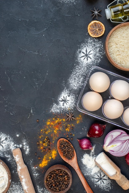 Foto gratuita vista dall'alto diversi ingredienti farina uova latte e condimenti su sfondo scuro colore pasta colazione latte uovo scuro