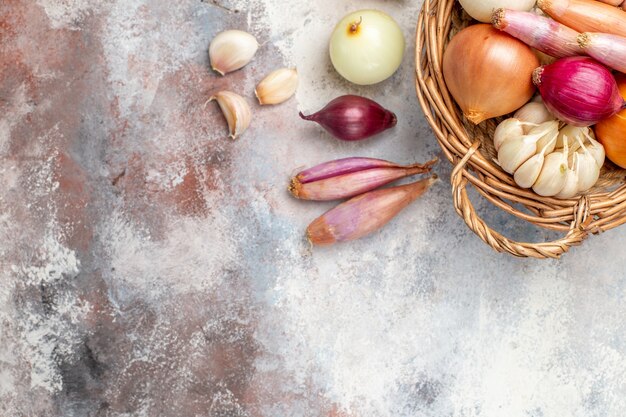 Top view different ingredients onions and garlic inside basket