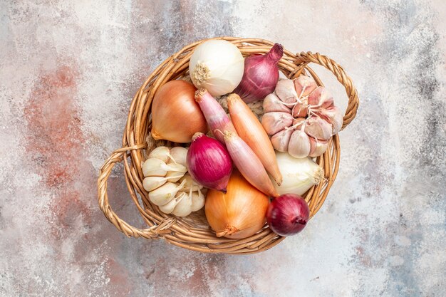 Top view different ingredients onions and garlic inside basket