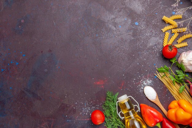 暗い背景の製品食品健康サラダダイエットのさまざまな成分生パスタと新鮮な野菜の上面図