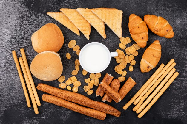 Top view of different kind of bread as crackers, toasts, croissants and milk