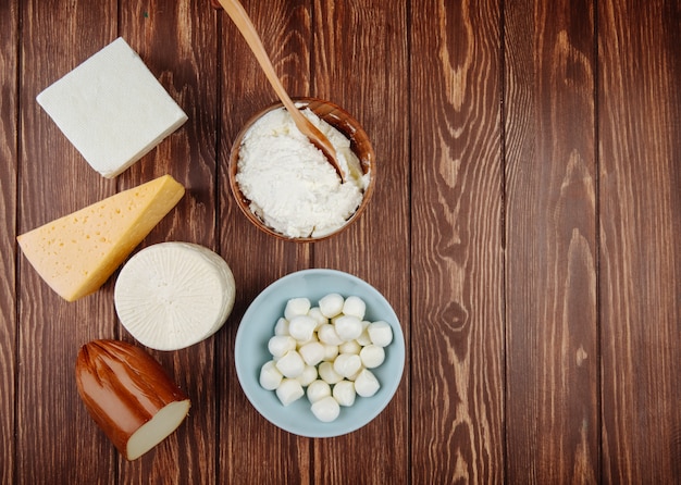 Top view of different kind of cheese on rustic wooden table