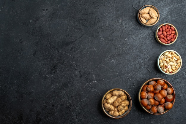 Top view different nuts hazelnuts and peanuts on grey background nut snack walnut food plant