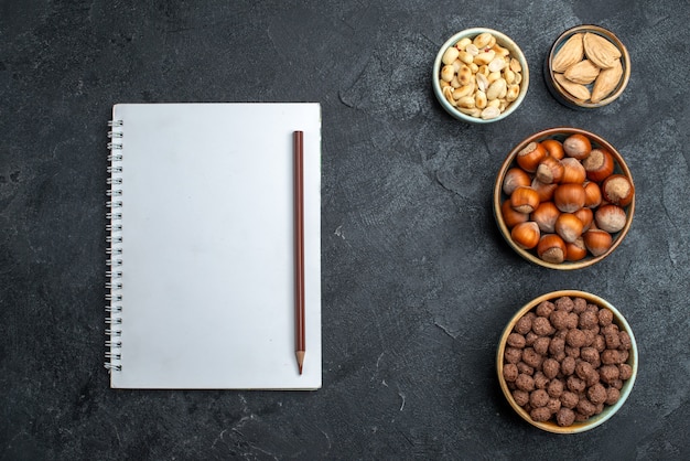 Top view different nuts hazelnuts and peanuts on grey background nuts snack walnut food plant