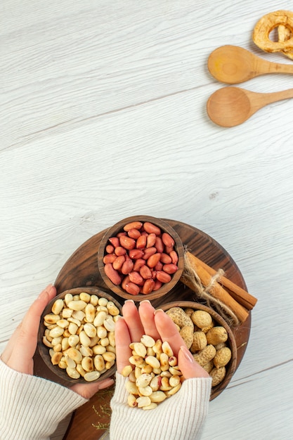 Free photo top view different nuts peanuts hazelnuts and walnuts on white table