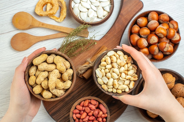 Top view different nuts peanuts hazelnuts and walnuts on white table