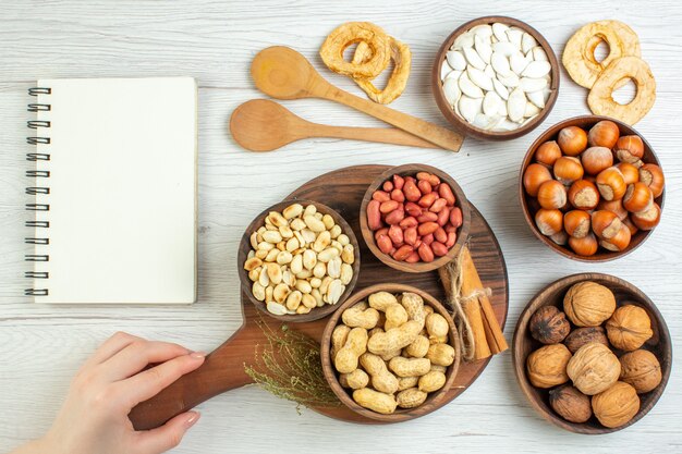 Top view different nuts peanuts hazelnuts and walnuts on white table