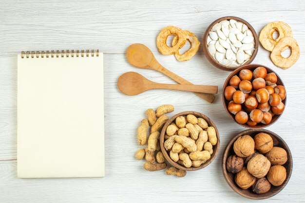 Вид сверху разные орехи арахис, фундук и грецкие орехи на белом столе