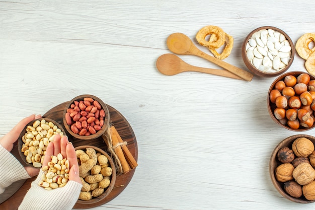 Top view different nuts peanuts hazelnuts and walnuts on white table