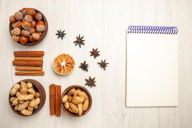 Top view different nuts with cinnamon on a white desk nut snack walnut hazelnut