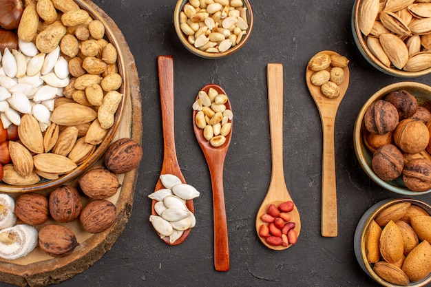 Top view of different nuts with confitures on a grey surface