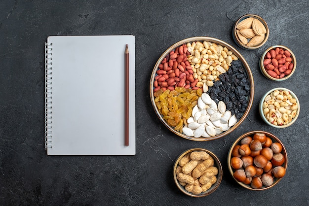 Top view different nuts with raisins and dried fruits on grey background nut snack raisin dry fruits nuts