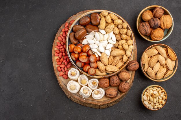 Top view of different nuts with white confitures on a grey surface