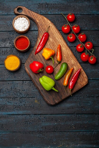 Top view different peppers with seasonings on dark desk