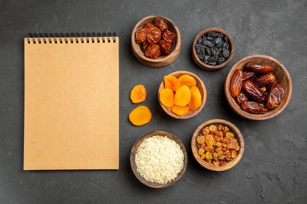 Top view different raisins with khurma on grey surface dry fruits raisin