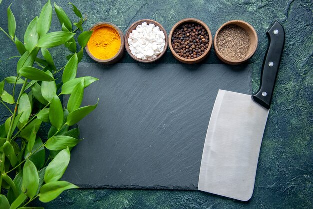 Top view different seasonings on a dark blue surface photo food spice salt pepper