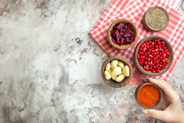 Top view different seasonings garlics pomegranates and beet on light background