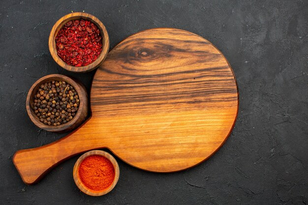 Top view different seasonings inside pots on grey space