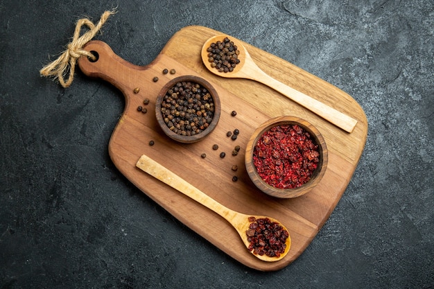 Top view different seasonings inside pots on grey space