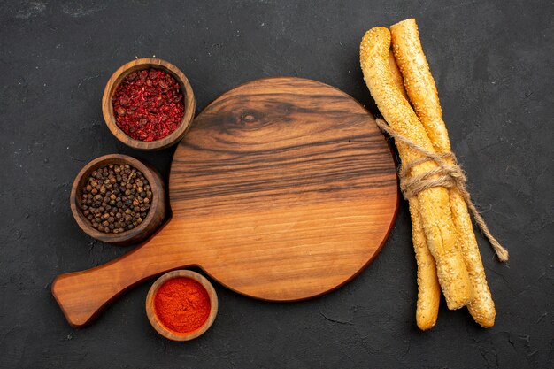 Top view different seasonings with bun bread on grey space