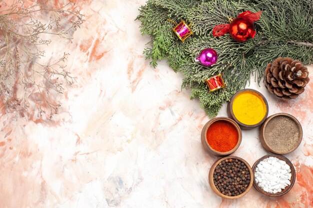 Top view different seasonings with christmas tree and toys on light background
