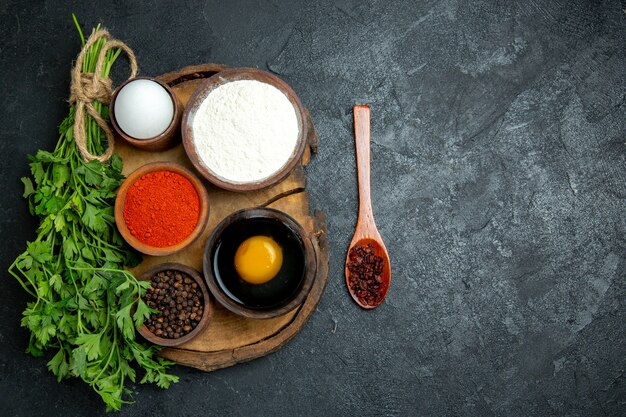 Top view different seasonings with egg and flour on grey space