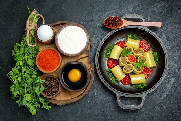 Top view different seasonings with egg pasta and flour on grey space