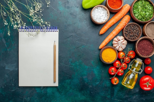 Foto gratuita vista dall'alto diversi condimenti con pomodori freschi sulla superficie verde scuro ingrediente prodotto pasto verdure alimentari