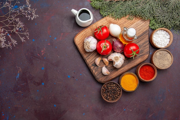 Top view of different seasonings with fresh vegetables on black floor ripe meal color plant tree