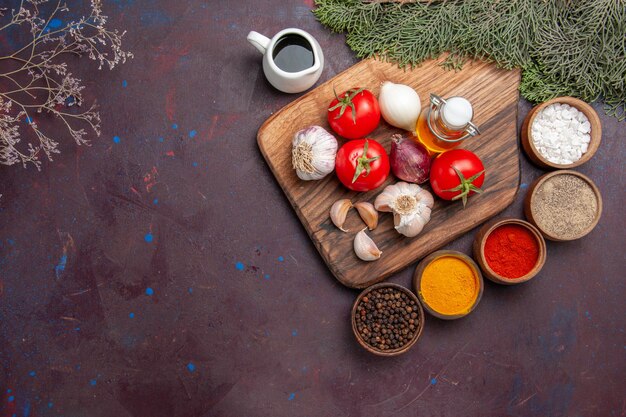 Top view of different seasonings with fresh vegetables on black floor ripe meal color plant tree