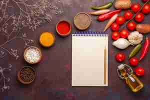 Free photo top view different seasonings with fresh vegetables on dark space