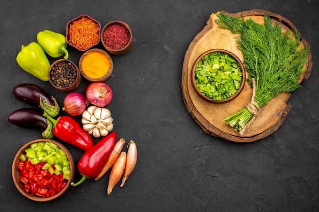 Top view different seasonings with fresh vegetables and greens on dark background ripe meal vegetable salad