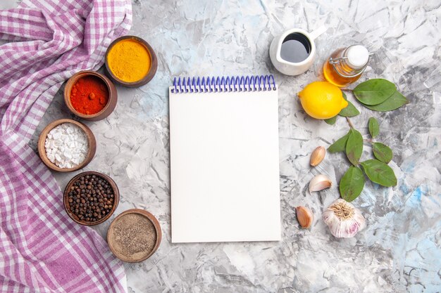 Top view different seasonings with garlic on a white table salt pepper fruit