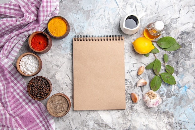 Free photo top view different seasonings with garlic on white table salt pepper fruit