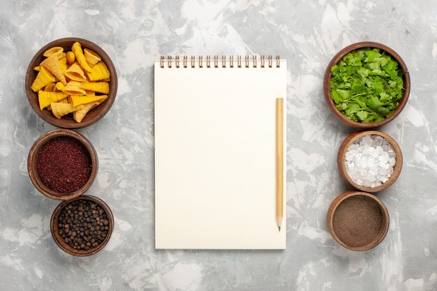 Top view different seasonings with greens on white surface