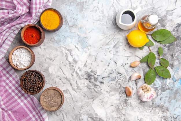 Top view different seasonings with lemon on white table oil spicy fruit salt