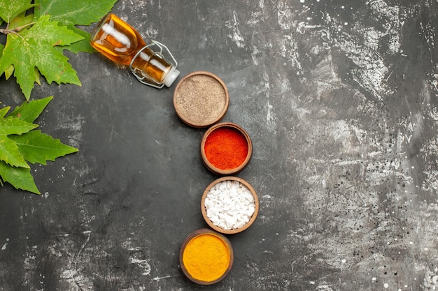 Top view different seasonings with oil on dark surface