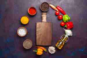 Foto gratuita vista dall'alto diversi condimenti con olio e verdure sulla superficie scura cibo pasto piccante vegetale