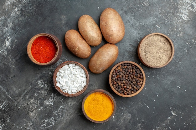 Top view different seasonings with potatoes