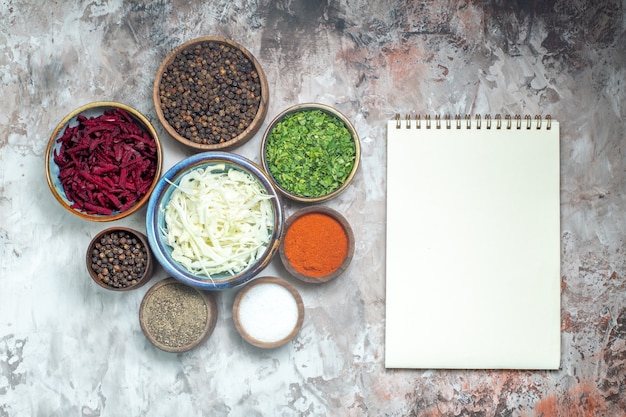 Top view different seasonings with sliced cabbage greens and beet on the white background