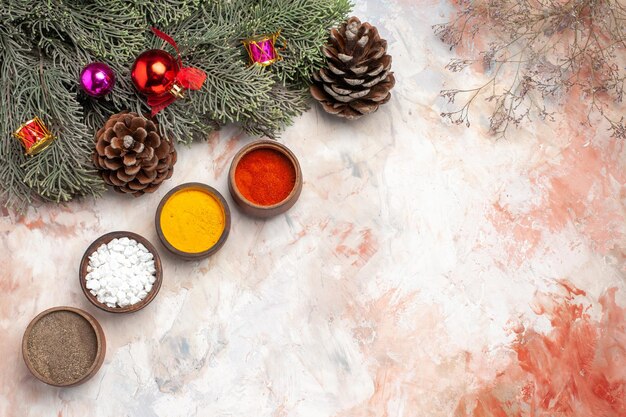 Top view different seasonings with tree and toys on light background