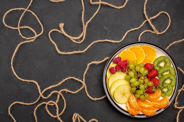 어두운 배경 다이어트 과일 신선하고 부드러운 익은 접시 안에 다른 얇게 썬 과일을 상위 뷰