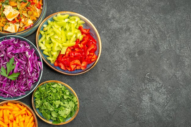 Top view different sliced vegetables with chicken salad on dark table health salad diet