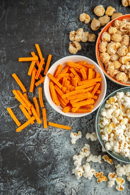 Top view different snacks for movie time on dark surface